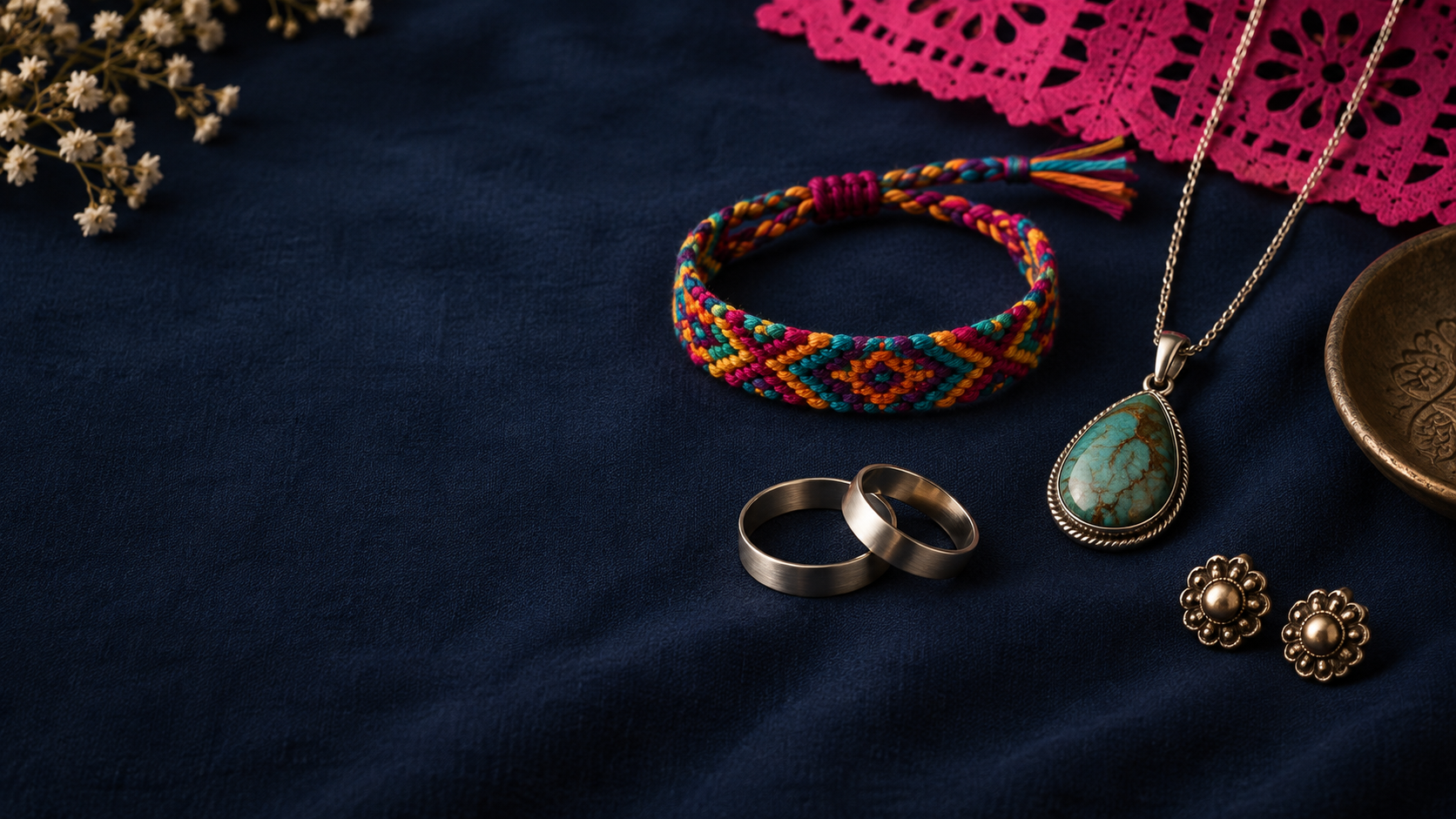 Pulsera tejida, collar de piedra, anillos y aretes sobre tela azul